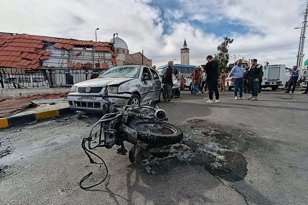 Syrian security personnel inspect the site of an explosion outside a Defense Ministry building in Damascus, Syria, Tuesday, May 19, 2026. (AP Photo/Abdulrahman Shaheen)