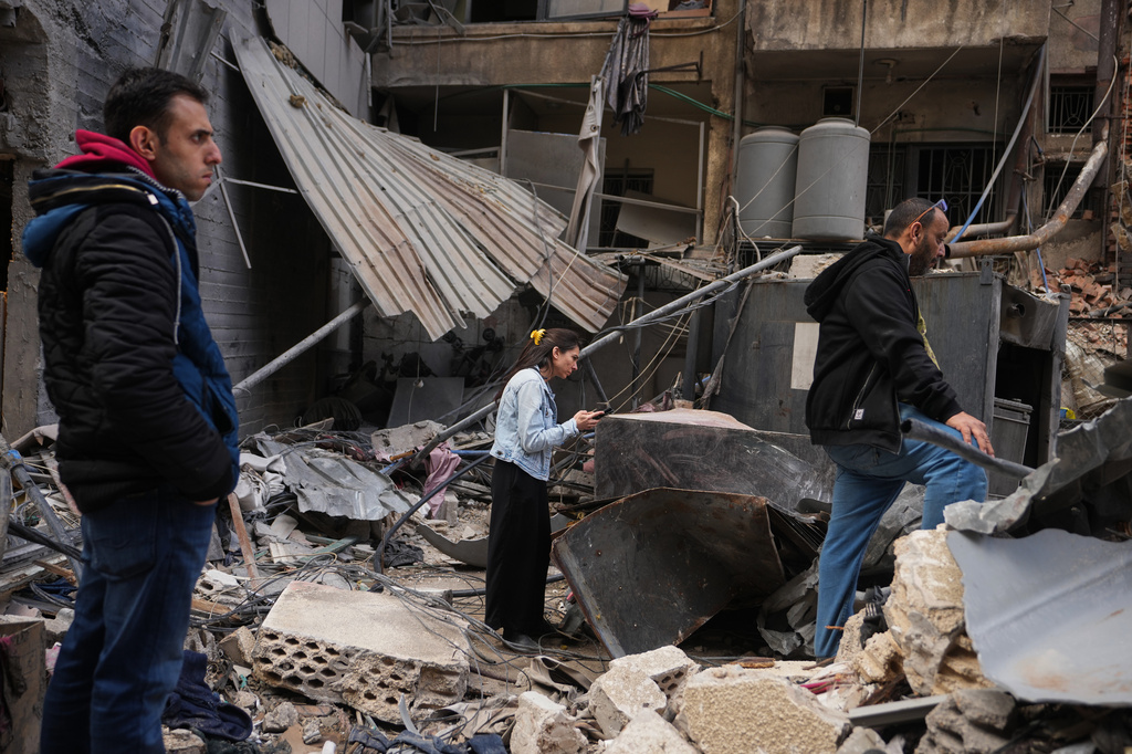 Residents inspect debris at the site of a building where efforts continue to recover the body of missing woman Zahraa Aboud, 26, after it was destroyed in an Israeli airstrike on Wednesday, in central Beirut, Sunday, April 12, 2026. (AP Photo/Hassan Ammar)