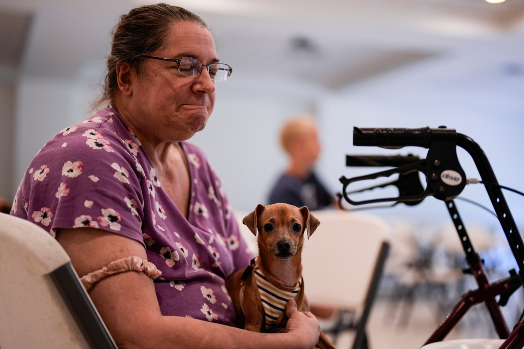 Jennifer Murphy and her dog Chip sit inside the Southside Baptist church as she is displanced by the Brantley Highway 82 fire, Friday, April 24, 2026, in Nahunta, Ga. (AP Photo/Mike Stewart)
