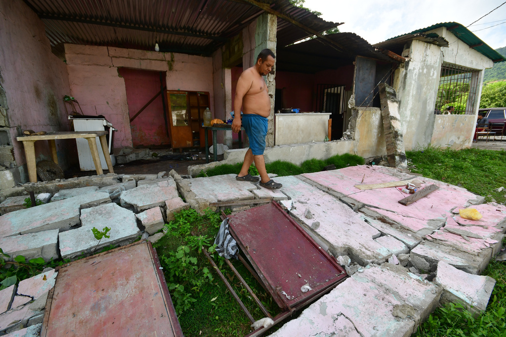 A man walks over the fallen walls of his home in Moron, near the epicenter of two earthquakes that struck Venezuela the day before, Thursday, June 25, 2026. (AP Photo/Jacinto Oliveros)