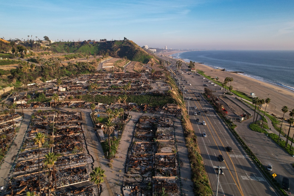 The remains of fire-damaged homes sit in a cleared-out block in the Palisades neighborhood of Los Angeles, Calif., Monday, Dec. 1, 2025. (AP Photo/Annika Hammerschlag)