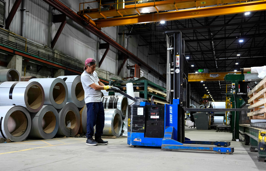 A worker operates a forklift in front of steel coils at the manufacturing plant of Ideal Roofing in Ottawa on Tuesday, Aug. 25, 2026. (Justin Tang/The Canadian Press via AP)