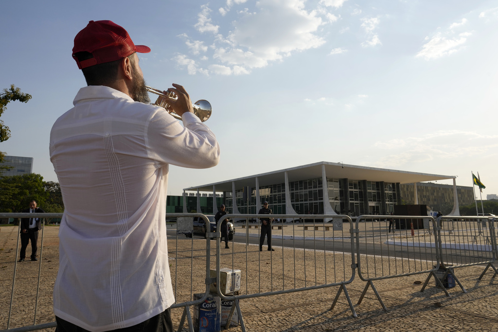 A trumpeter affiliated with the Workers' Party plays a samba song in celebration after the majority of a panel of Supreme Court justices voted to convict former President Jair Bolsonaro during his trial for a coup d'état, in front of the Supreme Court, in Brasilia, Brazil, Thursday, Sept. 11, 2025. (AP Photo/Eraldo Peres)