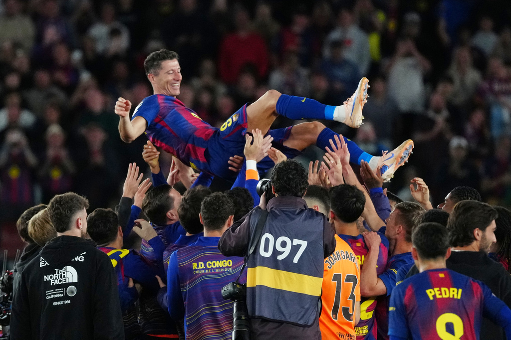 Barcelona's Robert Lewandowski is thrown into the air by his teammates after his last game for the club at the end of the Spanish La Liga soccer match between FC Barcelona and Real Betis in Barcelona, Spain, Sunday, May 17, 2026. (AP Photo/Joan Mateu Parra)