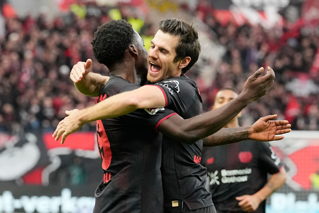 Leverkusen's Ernest Poku, left, celebrates with Leverkusen's Jonas Hofmann after scoring his side's opening goal during the German Bundesliga soccer match between Bayer Leverkusen and SC Freiburg in Leverkusen, Germany, Sunday, Oct. 26, 2025. (AP Photo/Martin Meissner)
