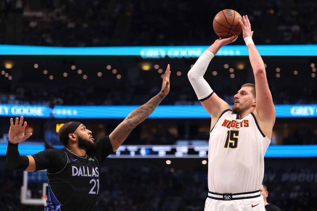 Denver Nuggets center Nikola Jokic (15) shoots over Dallas Mavericks forward Daniel Gafford (21) during the first quarter of an NBA basketball game Tuesday, Dec. 23, 2025, in Dallas. (AP Photo/Sam Hodde)