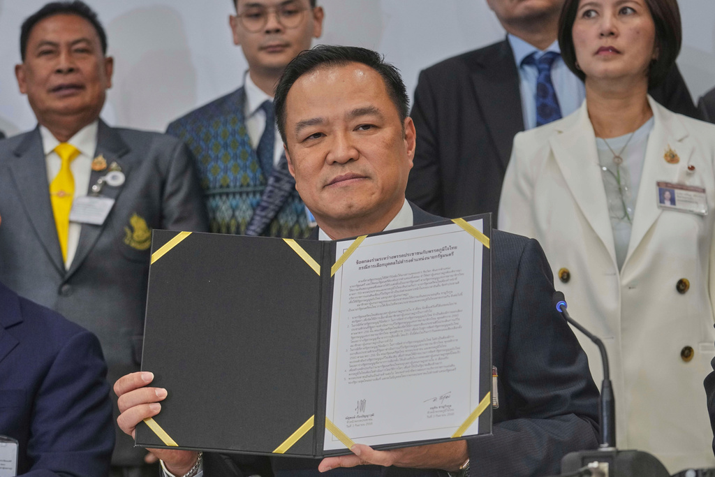 Leader of Bhumjai Thai Party Anutin Charnvirakul shows the signed Memorandum of Understanding between his coalition parties and the People's party at Parliament in Bangkok, Thailand, Wednesday, Sept. 3, 2025. (AP Photo/Sakchai Lalit)
