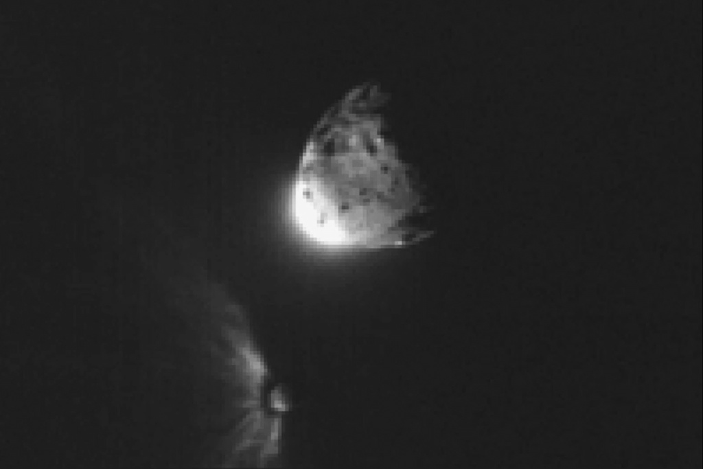 In this image provided by NASA, an impact plume emerges from the asteroid Dimorphos, left, after DART collided into it, Sept. 26, 2022.(NASA/ASI/University of Maryland/Tony Farnham/Nathan Marder via AP)