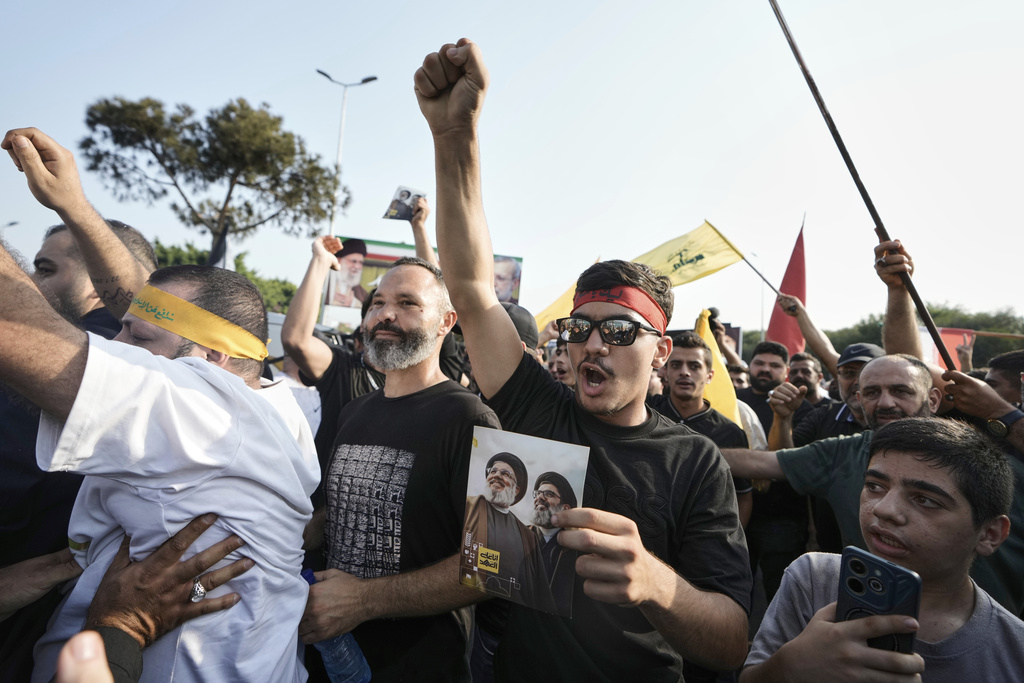 Hezbollah supporters chant slogans as they gather to welcome Ali Larijani, head of Iran's National Security Council, outside Rafik Hariri International Airport in Beirut, Lebanon, Wednesday, Aug. 13, 2025. (AP Photo/Bilal Hussein)