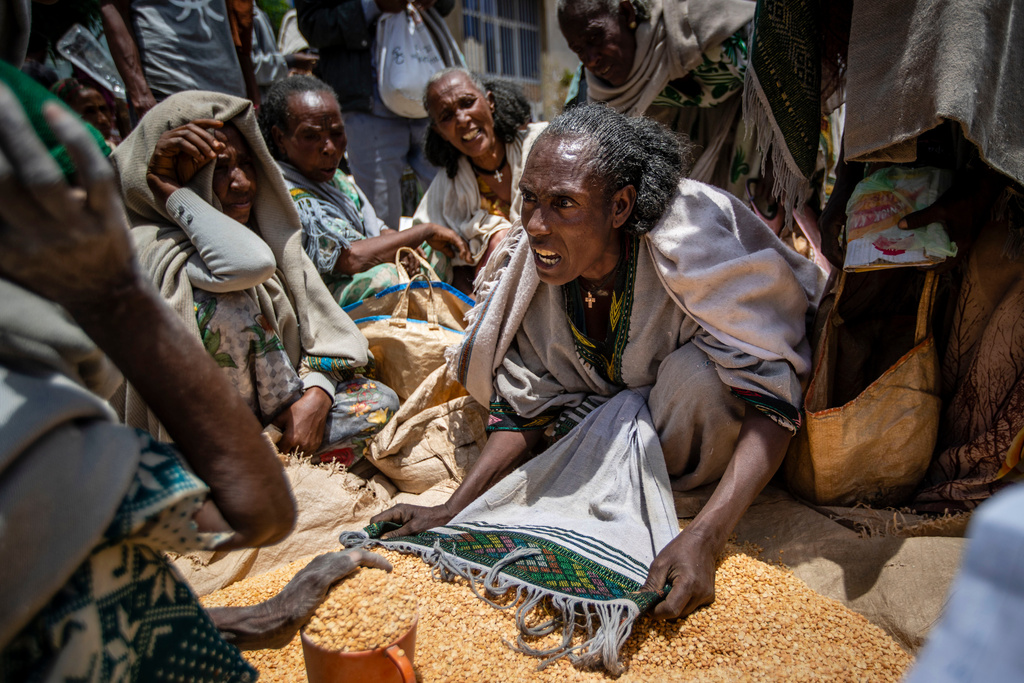 FILE - An Ethiopian woman argues with others over the allocation of yellow split peas after it was distributed by the Relief Society of Tigray in the town of Agula, in the Tigray region of northern Ethiopia, May 8, 2021. (AP Photo/Ben Curtis, File)