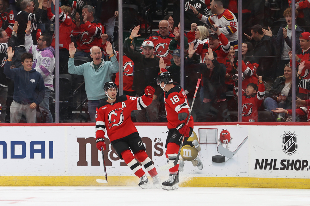 New Jersey Devils' Jack Hughes, left, and Ondrej Palat, right, react after Hughes scored during the first period of an NHL hockey game against the Colorado Avalanche Sunday, Oct. 26, 2025, in Newark, N.J. (AP Photo/Pamela Smith)