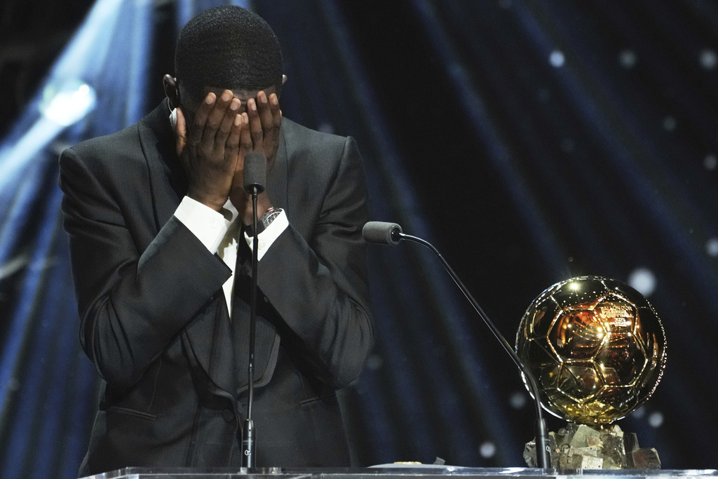 Paris Saint-Germain's Ousmane Dembélé reacts as he receives the 2025 Men's Ballon d'Or during the 69th Ballon d'Or awards ceremony at the Theatre du Chatelet in Paris, Monday, Sept. 22, 2025. (AP Photo/Thibault Camus)