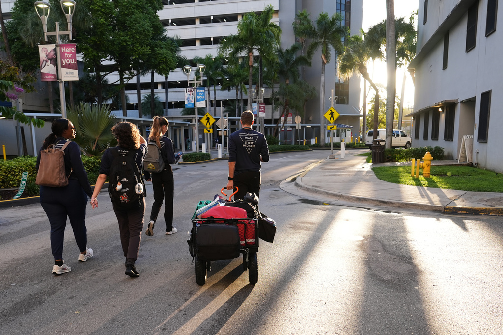Malachi Peterson-Hester, right, pulls a cart with medical supplies as the Miami Street Medicine team heads out to provide medical services to homeless people, Saturday, Sept. 20, 2025, in Miami. (AP Photo/Lynne Sladky)