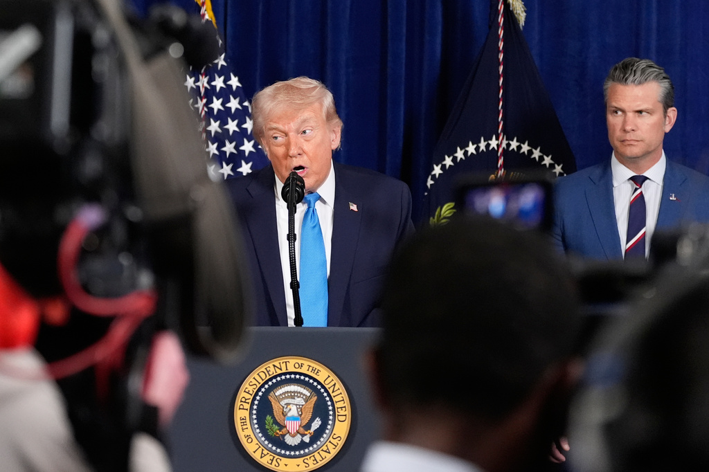 President Donald Trump speaks at his Mar-a-Lago club, Saturday, Jan. 3, 2026, in Palm Beach, Fla., as Defense Secretary Pete Hegseth listens. (AP Photo/Alex Brandon)