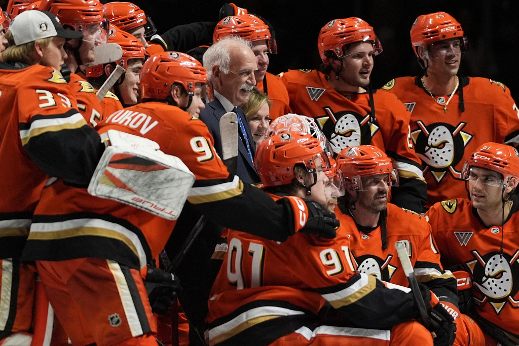 Anaheim Ducks head coach Joel Quenneville, center, poses with players and family after winning his 1,000th career coaching victory with a 6-4 win over the Edmonton Oilers in an NHL hockey game Wednesday, Feb. 25, 2026, in Anaheim, Calif. (AP Photo/Gregory Bull)