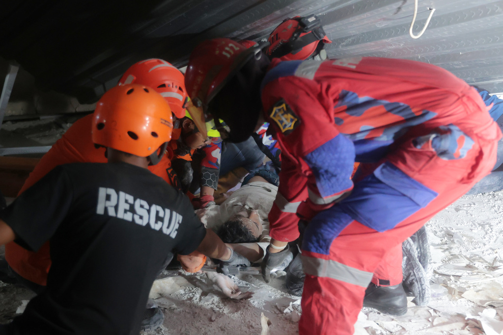 Rescuers pull out a survivor from a collapsed building at an Islamic boarding school in Sidoarjo, East Java, Indonesia, Monday, Sept. 29, 2025. (AP Photo/Trisnadi)