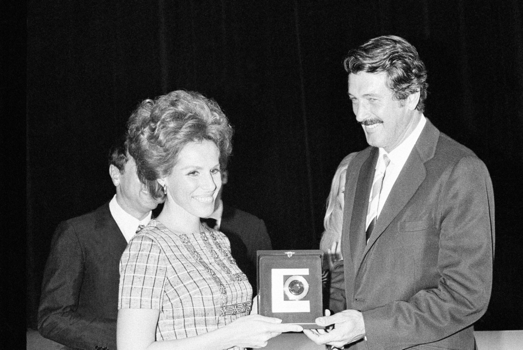 FILE - American actor Rock Hudson hand the "Golden Record" to Italian singer Ornella Vanoni, at a ceremony in the "Piccolo Teatro" (Little Theatre), Milan, Sept. 15, 1969. (AP Photo/Raoul Fornezza, File)