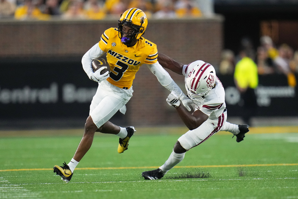 Missouri wide receiver Kevin Coleman Jr., left, runs with the ball as Massachusetts defensive lineman Zachary Farris defends during the first half of an NCAA college football game Saturday, Sept. 27, 2025, in Columbia, Mo. (AP Photo/Jeff Roberson)