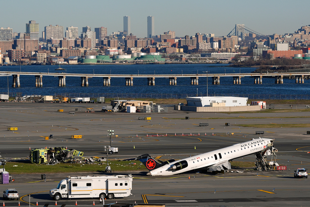 An Air Canada Express jet and Port Authority fire truck lay on the side of a runway at LaGuardia Airport, Tuesday, March 24, 2026, after colliding with each other shortly after the jet landed in New York Sunday night. (AP Photo/Yuki Iwamura)