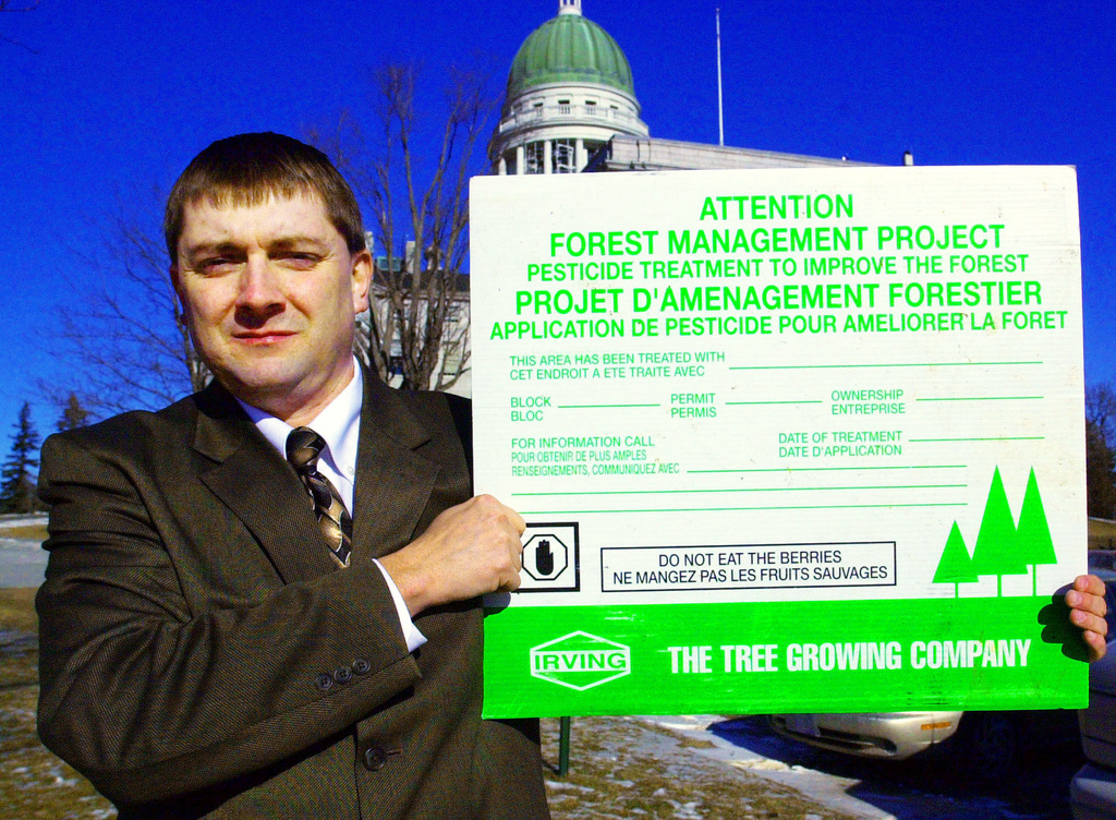FILE - Rep. Troy Jackson, D-Fort Kent, holds up a poster warning people not to eat berries from sprayed areas treated by paper companies, outside the State House, in Augusta, Maine, Wednesday, Jan. 28, 2004. (AP Photo/Pat Wellenbach,File)