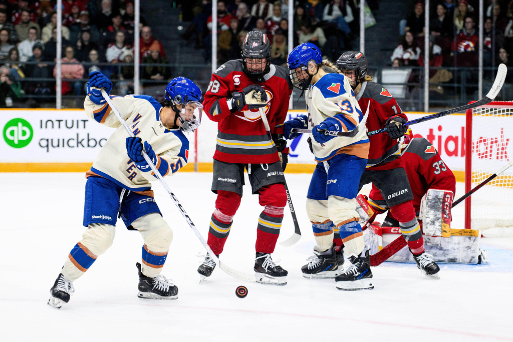 Ottawa Charge's Ronja Savolainen (88) and Vancouver Goldeneyes' Tereza Vanisova (13) track the puck as Goldeneyes' Anna Segedi (51) tries to maintain possession during the second period of an PWHL hockey game in Ottawa, Friday, Jan. 9, 2026. (Spencer Colby/The Canadian Press via AP)