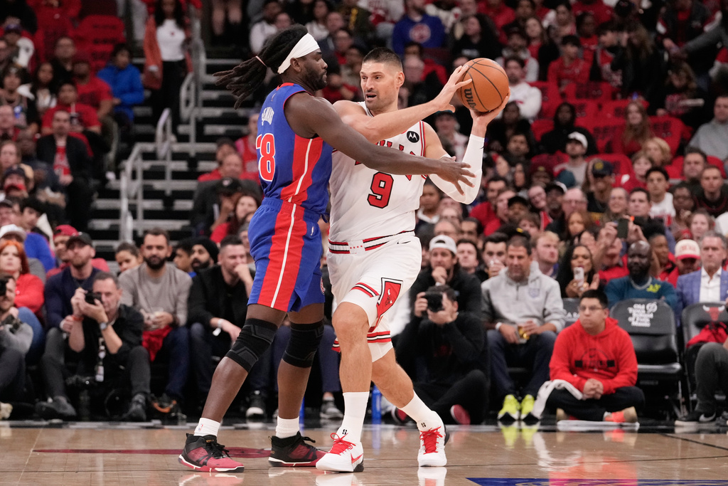 Chicago Bulls center Nikola Vučević, right, looks to a pass as Detroit Pistons center Isaiah Stewart guards during the first half of an NBA basketball game in Chicago, Wednesday, Oct. 22, 2025. (AP Photo/Nam Y. Huh)