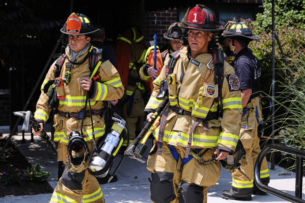 Firefighters respond to a fire while wearing recently issued non-PFAS turnout gear on July 3, 2025, in East Providence, R.I. (AP Photo/Charles Krupa)