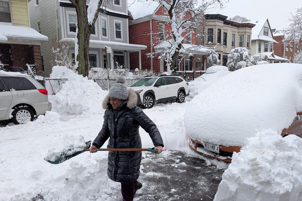 Christa Prince shovels snow during a blizzard in the borough of Brooklyn, New York, on Monday, Feb. 23, 2026. (AP Photo/Drew Callister)