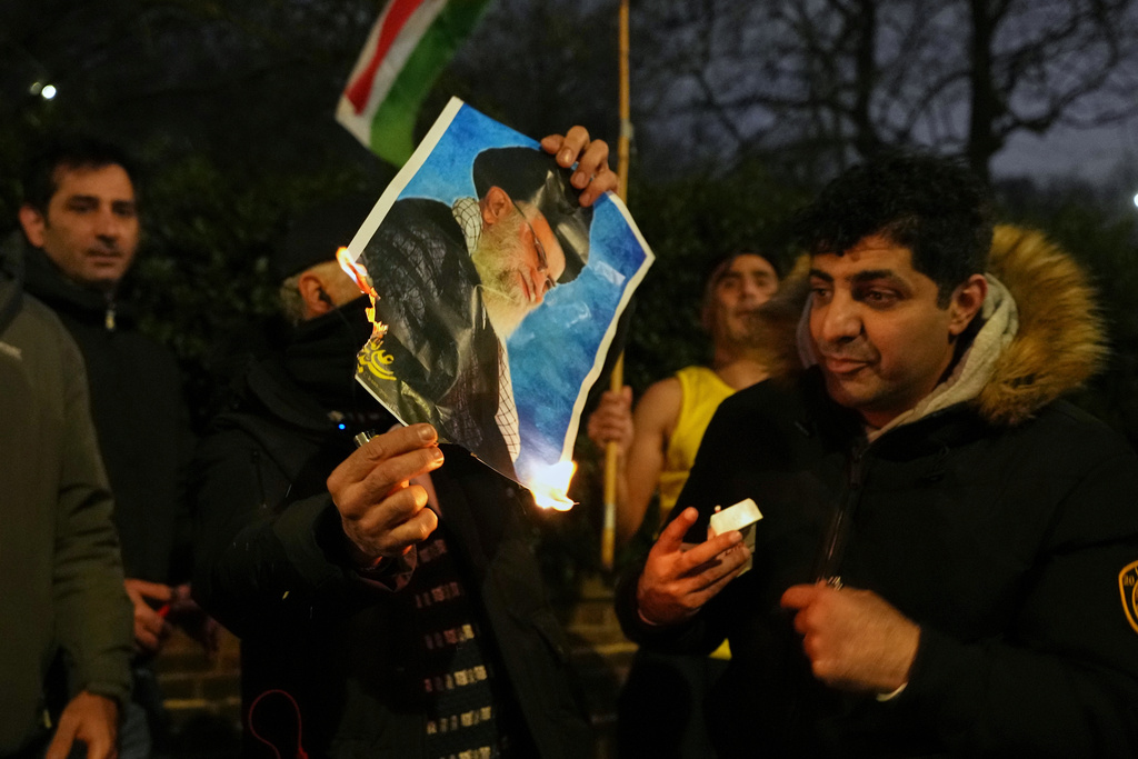 A picture of Ayatollah Ali Khamenei is set alight by protesters outside the Iranian Embassy in London, Monday, Jan. 12, 2026. (AP Photo/Alastair Grant)