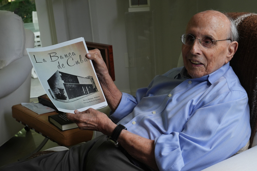 Raul Valdes-Fauli holds a picture of the family-owned Pedroso Bank in Havana during an interview Tuesday, April 21, 2026, in Coral Gables, Fla. (AP Photo/Marta Lavandier)