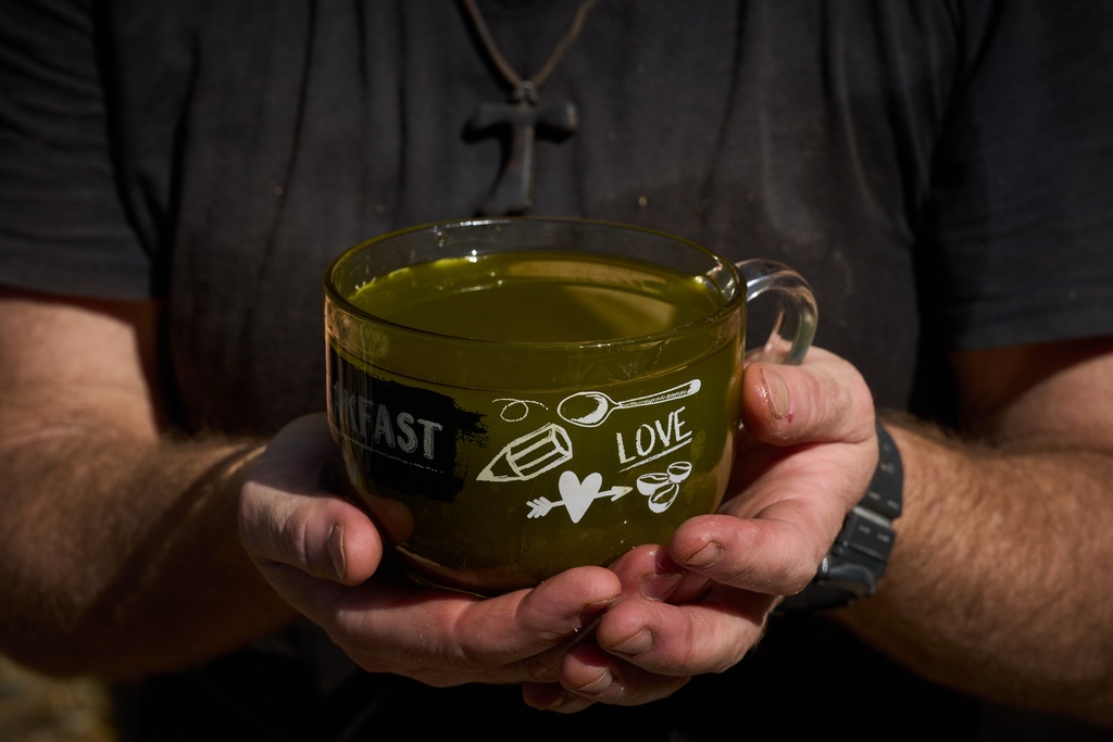 The Rev. Diego Dalla Gassa poses with a cup of just-pressed olive oil during the harvest at the Franciscan hermitage on the Mount of Olives, in Jerusalem, Friday, Oct. 3, 2025. (AP Photo/Oded Balilty)