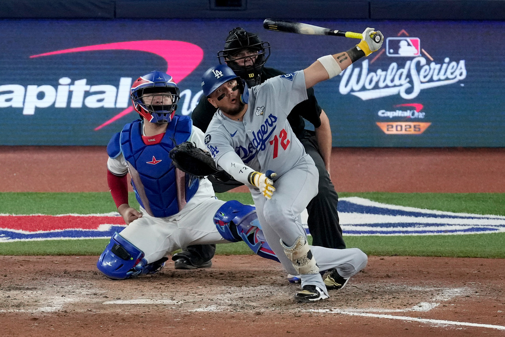 Los Angeles Dodgers' Miguel Rojas follows through on a home run against the Toronto Blue Jays during the ninth inning in Game 7 of baseball's World Series, Saturday, Nov. 1, 2025, in Toronto. (AP Photo/Ashley Landis)