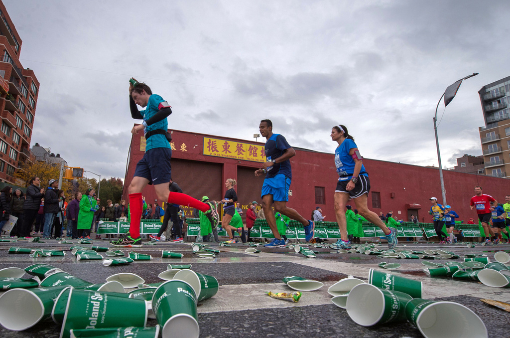 FILE - Runners pass through a water station during the New York City Marathon, Sunday, Nov. 1, 2015, in the Brooklyn borough of New York. (AP Photo/Bryan R. Smith, File)