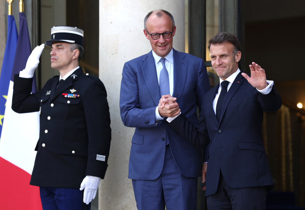 French President Emmanuel Macron, right, greets German Chancellor Friedrich Merz ahead of a multinational virtual summit at the Elysee Presidential Palace in Paris, Friday April 17, 2026 (Tom Nicholson/Pool Photo via AP)