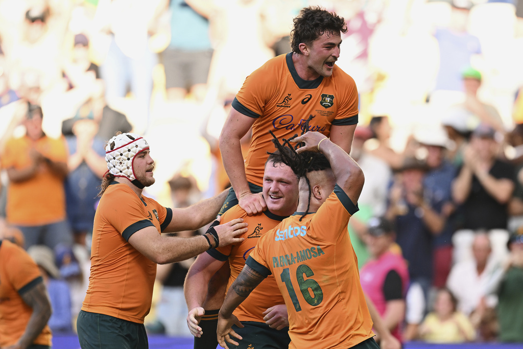Angus Bell, bottom center, of the Wallabies is congratulated by teammates after scoring the match winning try during the rugby international between Australia and Argentina in Townsville, Australia, Saturday, Sept. 6, 2025. (Dave Hunt/AAP Image via AP)