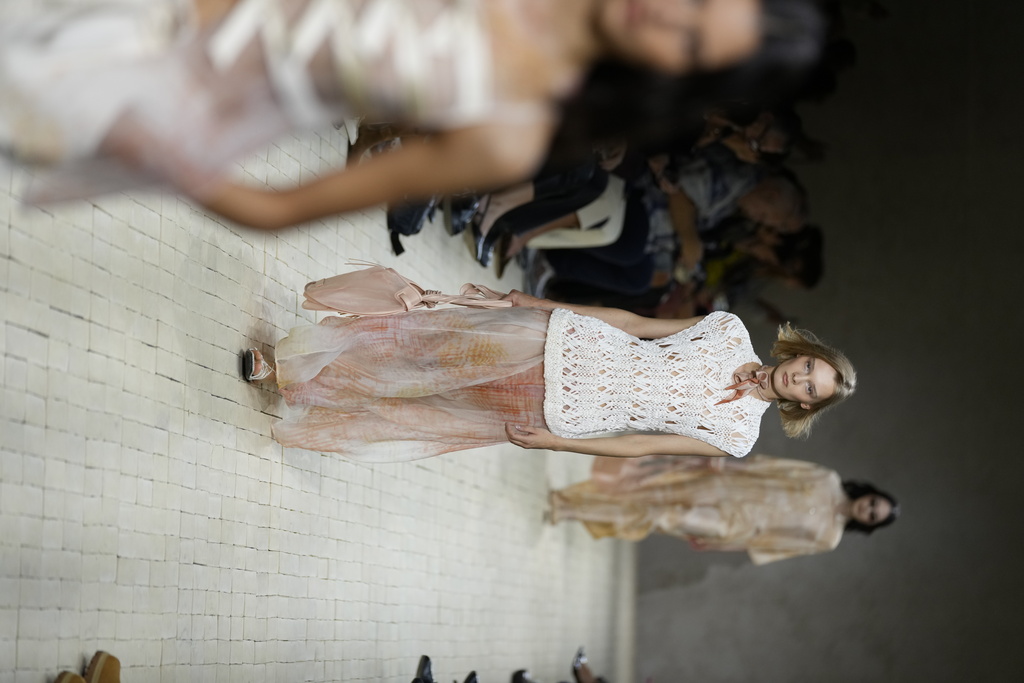 Models claps their hands as they wear creations part of the Emporio Armani women's Spring-Summer 2026 collection, presented in Milan, Italy, Thursday, Sept. 25, 2025. (AP Photo/Luca Bruno)