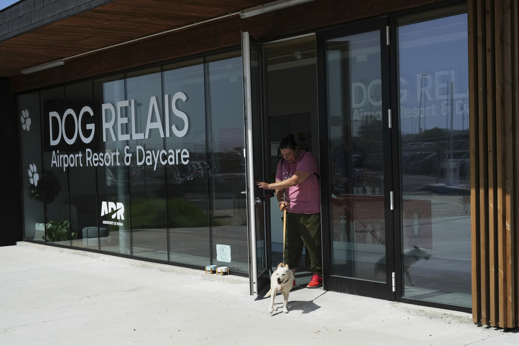 A costumer walks with her dog as she leaves the Dog Relais, a hotel for dogs at Rome's Fiumicino International Airport, Wednesday, Sept. 17, 2025. (AP Photo/Alessandra Tarantino)