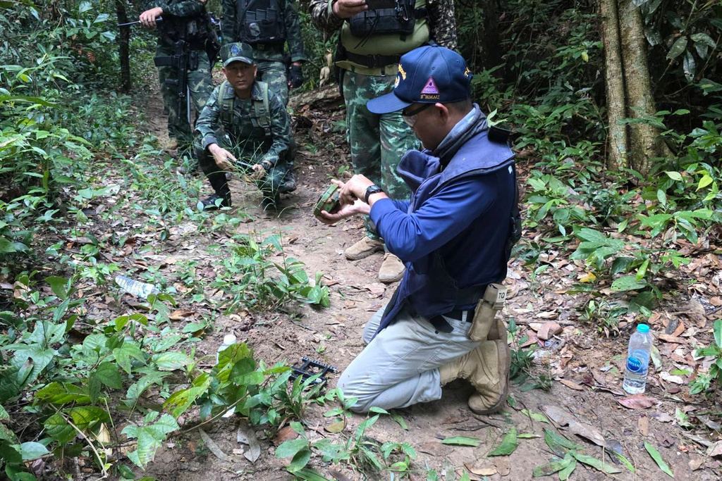 In this photo released by the Royal Thai Army, a Thai officer inspects a landmine near the Thai-Cambodia border in Sisaket province, Thailand, Monday, Nov. 10, 2025. (Royal Thai Army via AP)