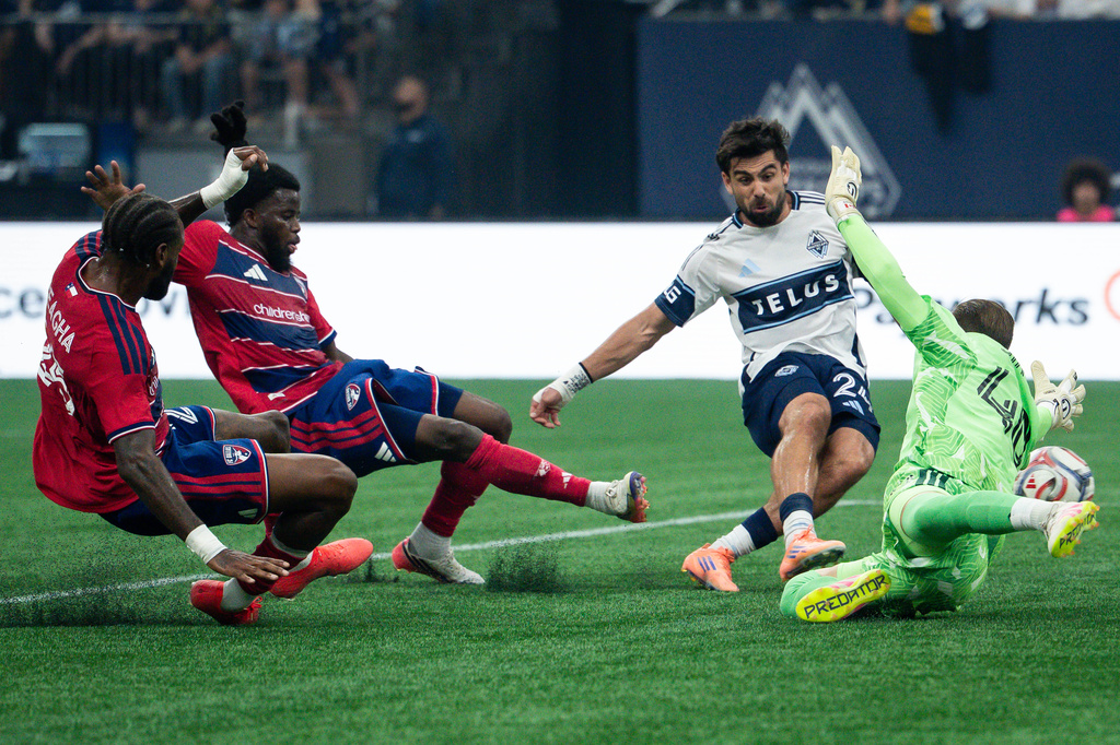 Vancouver Whitecaps' Brian White (24) scores on FC Dallas goalkeeper Jonathan Sirois (40) as FC Dallas' Sebastien Ibeagha, left, and Lalas Abubakar (5) defend during the first half of an MLS soccer match in Vancouver, British Columbia, Saturday, Aug. 22, 2026. (Ethan Cairns/The Canadian Press via AP)