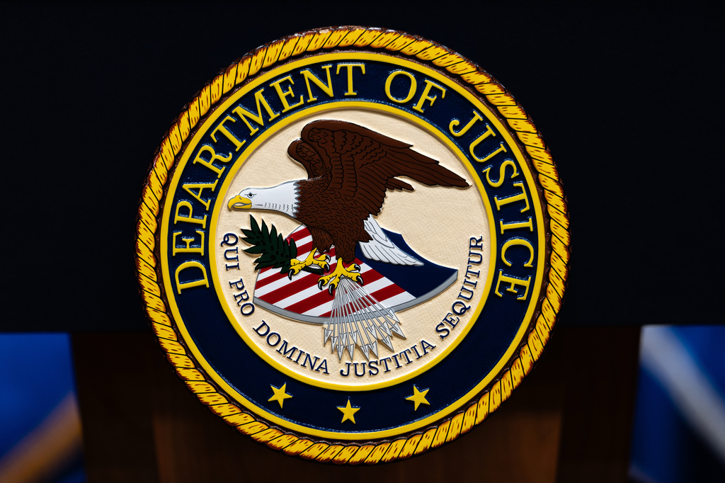 The U.S. Department of Justice logo is seen on a podium before a news conference, Monday, May 4, 2026, in Washington. (AP Photo/Julia Demaree Nikhinson)