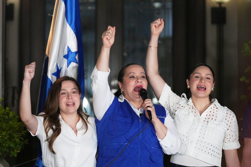 Ana García, center, wife of former Honduras' President Juan Orlando Hernández and his daughters Daniela, left, and Isabela raise their fists in Tegucigalpa, Honduras, Friday, Nov. 28, 2025 after U.S. President Donald Trump said he would pardon Hernández, who is serving a 45-year prison sentence for helping import cocaine to the United States. (AP Photo/Moises Castillo)