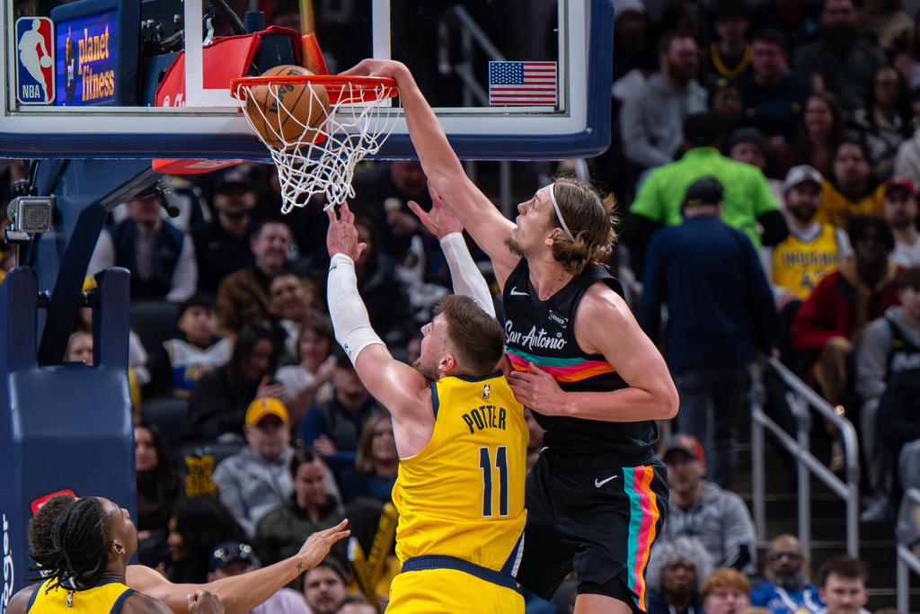 San Antonio Spurs forward Kelly Olynyk, right, scores over the top of Indiana Pacers center James Wiseman (11) during the first half of an NBA basketball game in Indianapolis, Friday, Jan. 2, 2026. (AP Photo/Doug McSchooler)