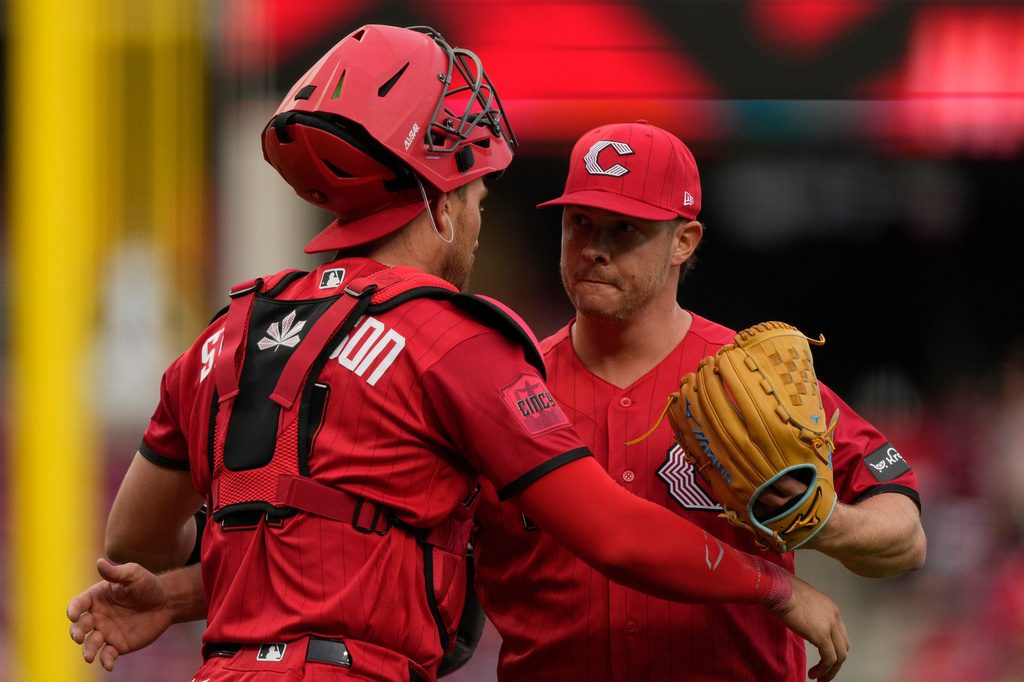 Cincinnati Reds pitcher Emilio Pagán, right, and Cincinnati Reds catcher Tyler Stephenson, left, embrace after winning a baseball game against the Los Angeles Angels in Cincinnati, Saturday, April 11, 2026. (AP Photo/Carolyn Kaster)