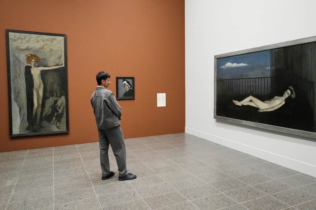 A man looks at artworks by Romaine Brooks at the new exhibition "Queer Modernism. 1900 to 1950" at the Kunstsammlung NRW museum in Duesseldorf, Germany, highlighting the contributions of queer artists to modernism. (AP Photo/Martin Meissner)