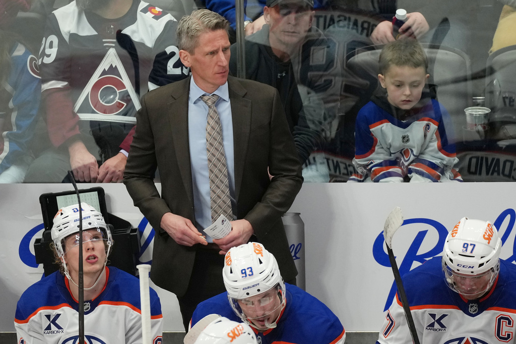 FILE - Edmonton Oilers head coach Kris Knoblauch looks on from behind the bench during the third period of an NHL hockey game, Tuesday, March 10, 2026, in Denver. (AP Photo/David Zalubowski, File)