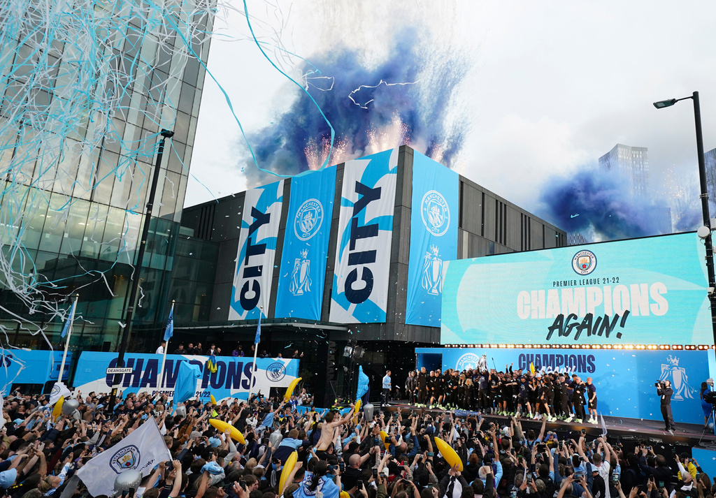 FILE - Flares and tape are let off as Manchester City's players celebrate on stage as fans watch the winners parade as the team celebrates winning the English Premier League title in Manchester, England, Monday, May 23, 2022. (AP Photo/Jon Super, File)