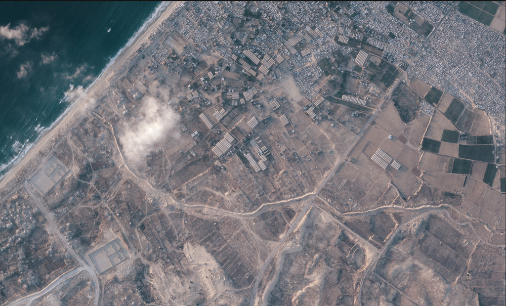 A satellite image from Planet Labs PBC shows a section of an earthen barrier, cutting horizontally across the middle of the image, being built by the Israeli military in the southern Gaza Strip, July 15, 2026. On one side are two military bases, and on the other the Palestinian tent city of Muwasi. (Planet Labs PBC via AP)