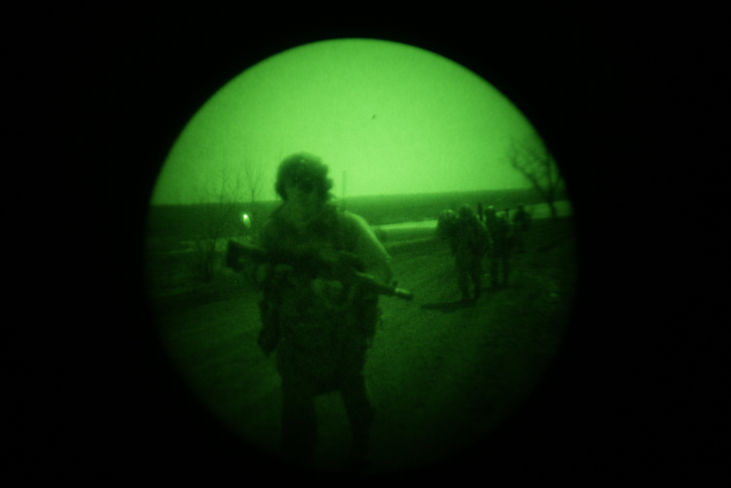 In this March 20, 2024 photo made through night vision goggles, Ukrainian serviceman Danyil Smyrnov participates in an infantry mission in Umanske, Adviivka direction, Ukraine. (AP Photo/Alex Babenko)