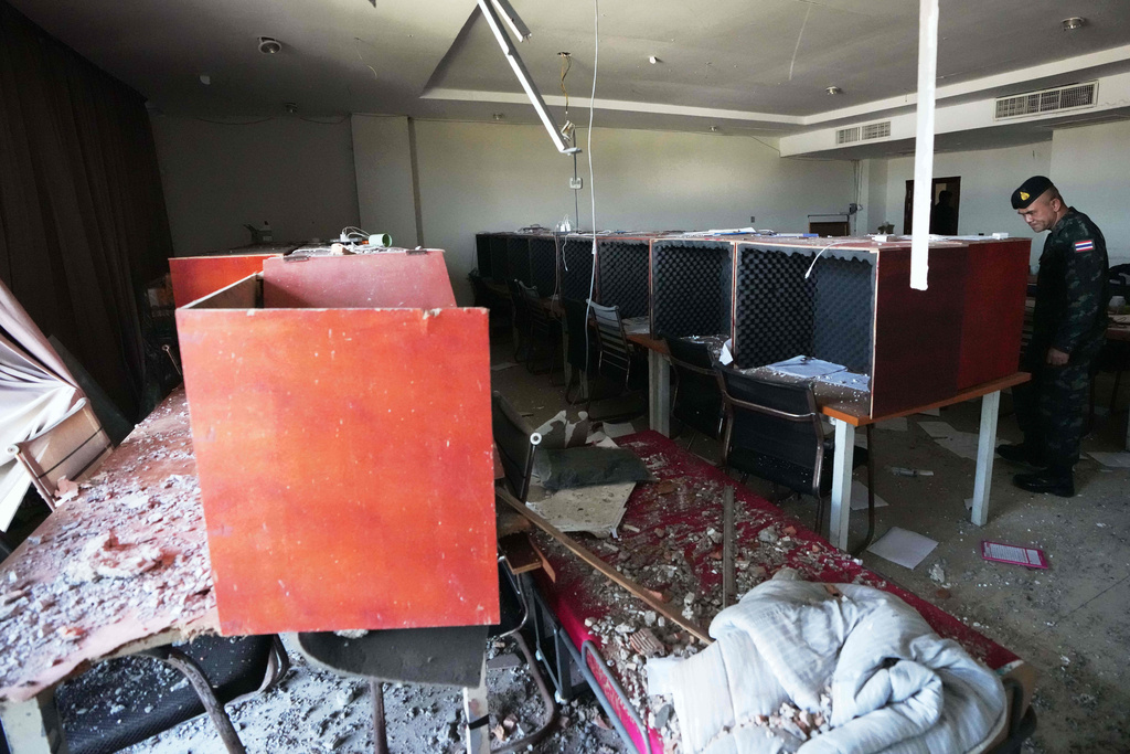 FILE - A Thai soldier inspects a work station with wooden phone booths lined with foam for soundproofing, inside a scam compound in O'Smach, Cambodia, Monday, Feb. 2, 2026. (AP Photo/Sakchai Lalit, File)