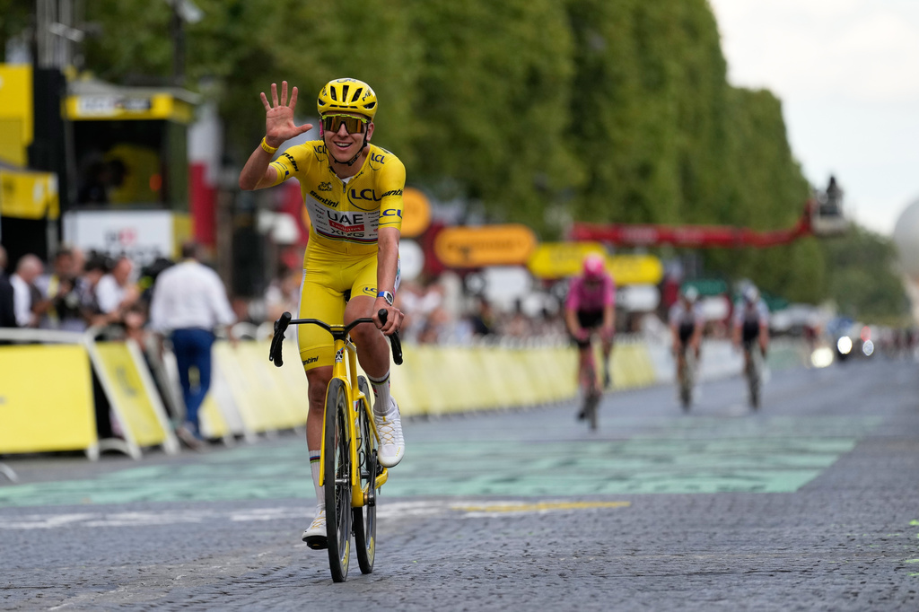 Slovenia's Tadej Pogacar, wearing the overall leader's yellow jersey, celebrates as he crosses the finish line of the last stage of the Tour de France cycling race with start and finish in Paris, Sunday, July 26, 2026. (AP Photo/Mosa'ab Elshamy)